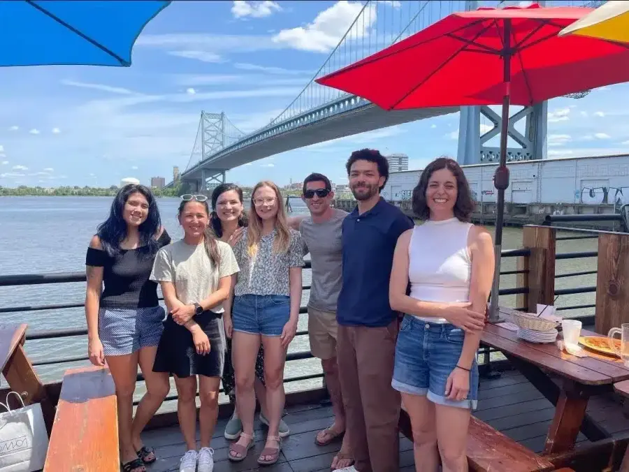 GetPhound team members on a riverfront deck with a bridge behind them